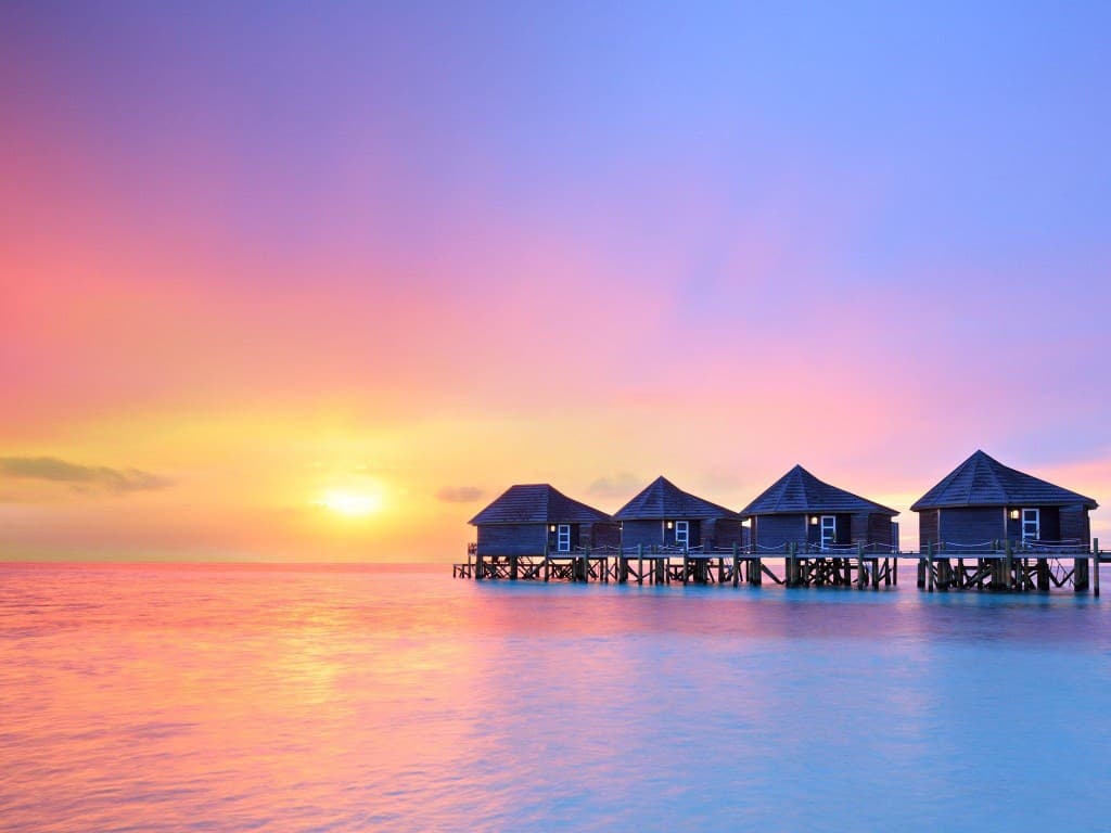 Pastel sunset over Maldivian water villas