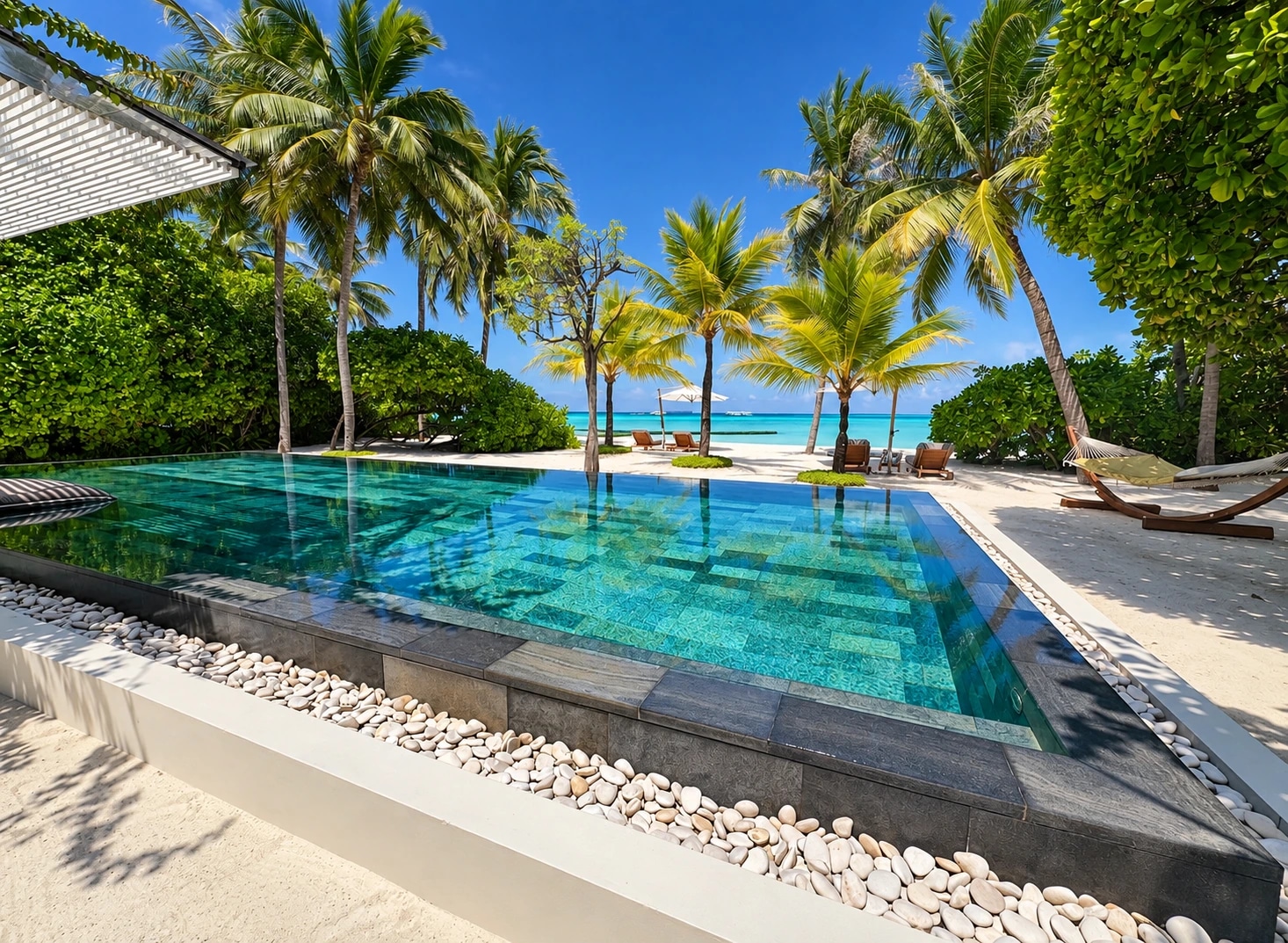 Private pool framed by palms facing the beach at Cheval Blanc Randheli
