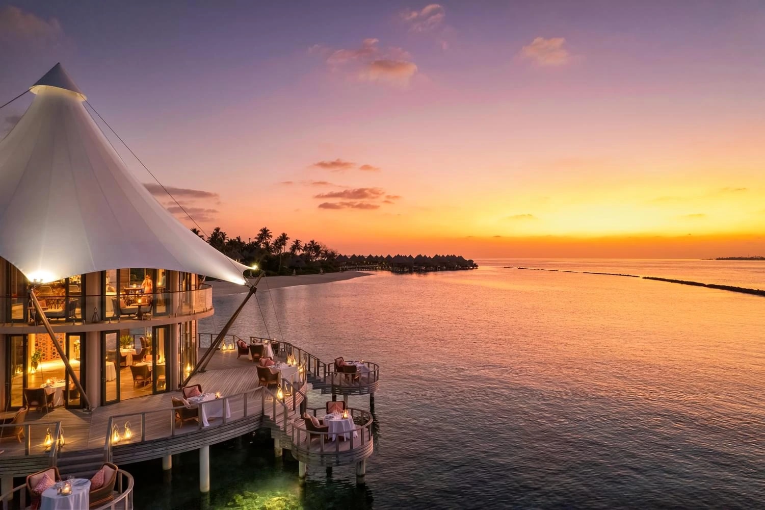 Restaurant sur pilotis au coucher du soleil à The Nautilus Maldives