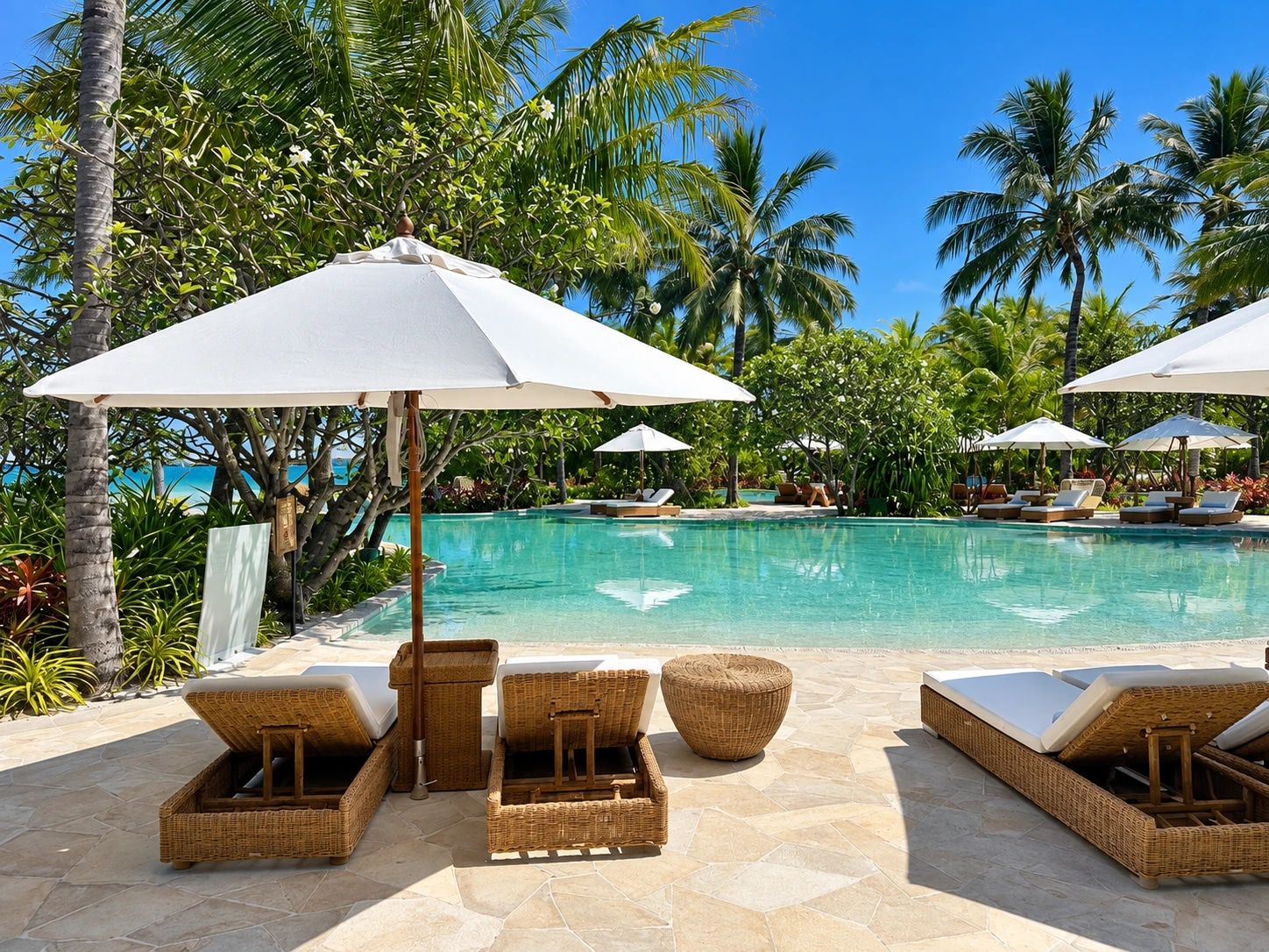 Piscine bordée de palmiers et bains de soleil au Waldorf Astoria Maldives Ithaafushi
