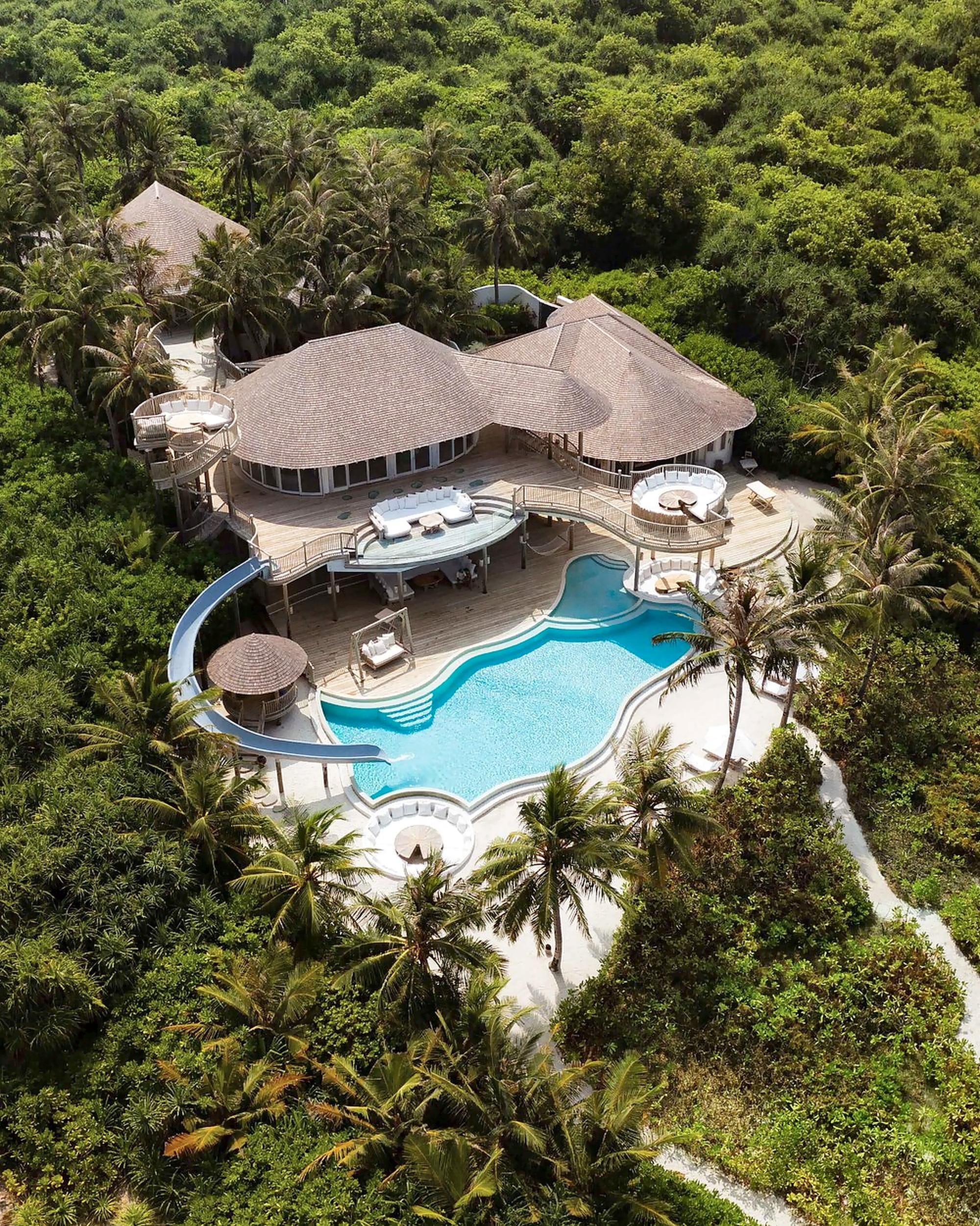 Aerial view of a villa and its pool among the greenery of Soneva Jani