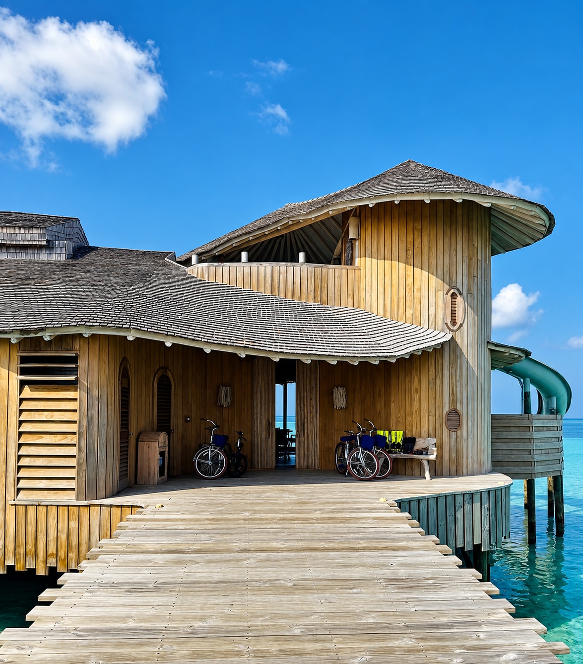Passerelle menant à l’entrée d’une villa sur pilotis avec des vélos à Soneva Jani